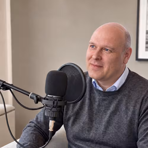 Mirko Otto am Podcast-Mikrofon im Büro