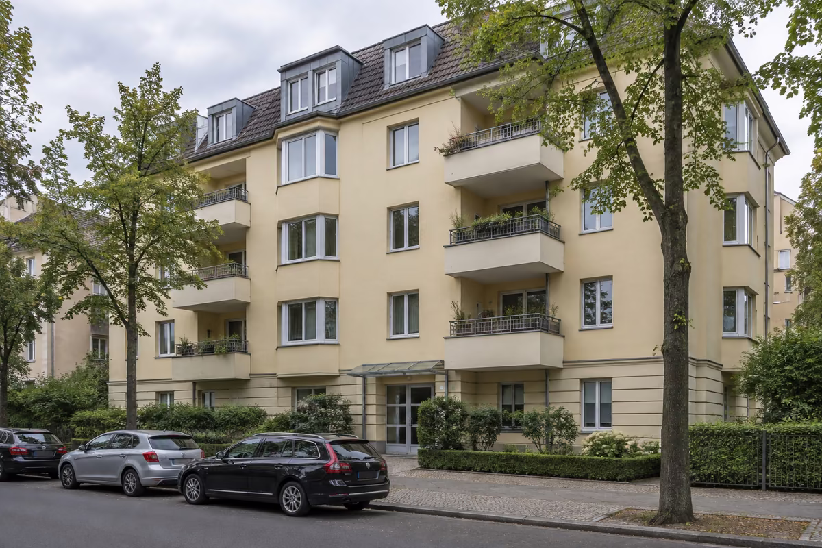 Musterfoto: helles Mehrfamilienhaus mit Balkonen an einer Berliner Straße, in dem die Eigentumswohnung des Musters liegt