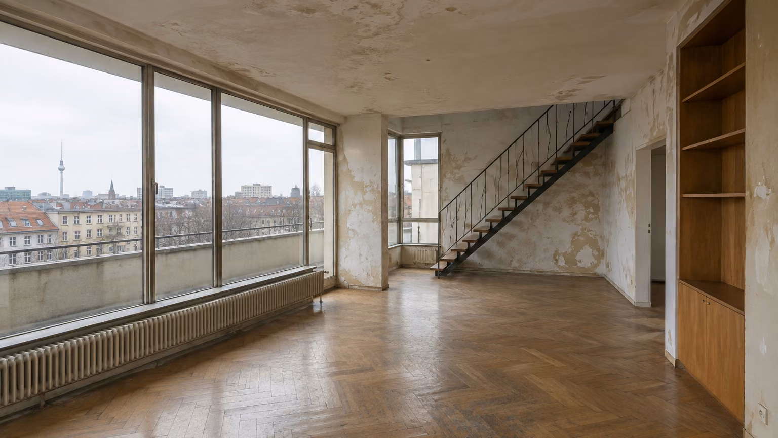 Illustratives Motiv: Wohnzimmer einer Wohnung aus den 1950er-Jahren in schlechtem Zustand, mit abblätternder Farbe, abgenutztem Parkett und Fensterfront über Berliner Dächern.