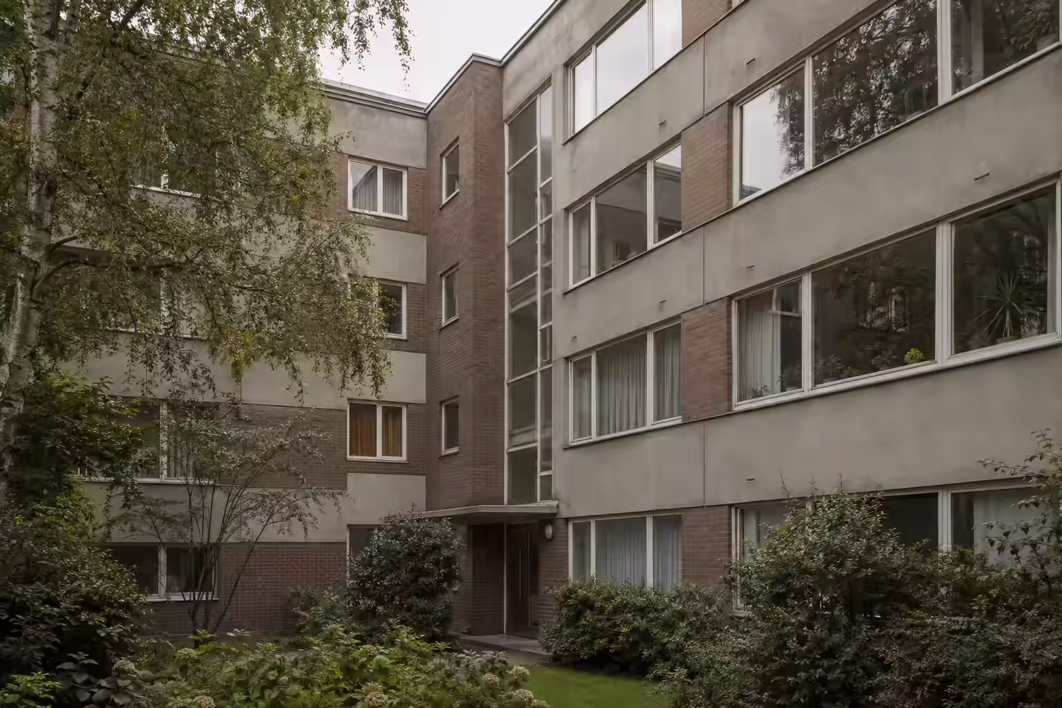 Beispielmotiv: mehrgeschossiges Wohnhaus der Nachkriegsmoderne.